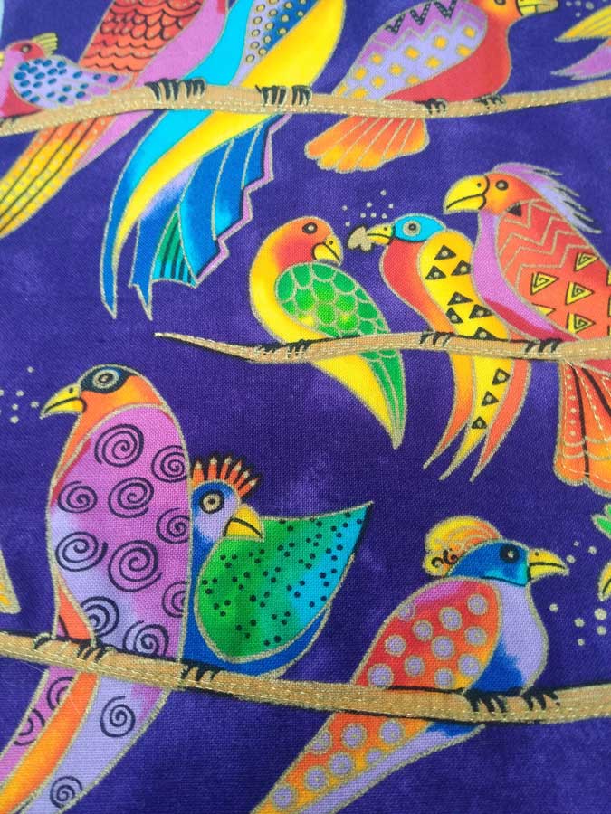 Decorative stitching on parrot-themed fabric