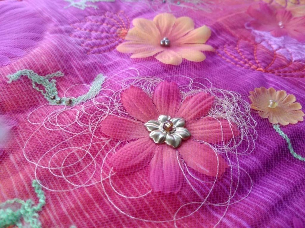 silk flower on fabric with beads and thread