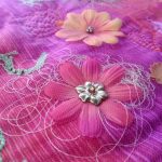 silk flower on fabric with beads and thread