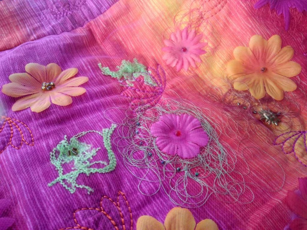 silk flower on fabric with thread and beads